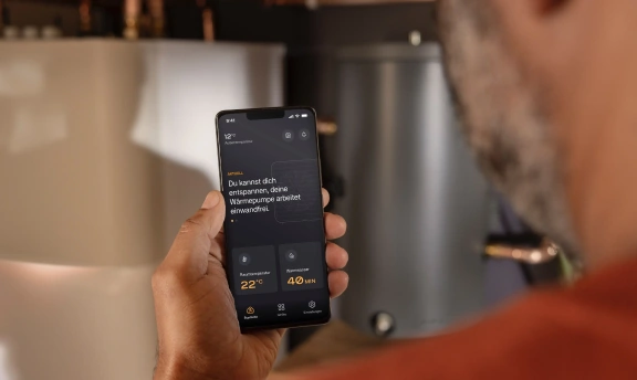 Mann hält Mobiltelefon mit Photovoltaik App